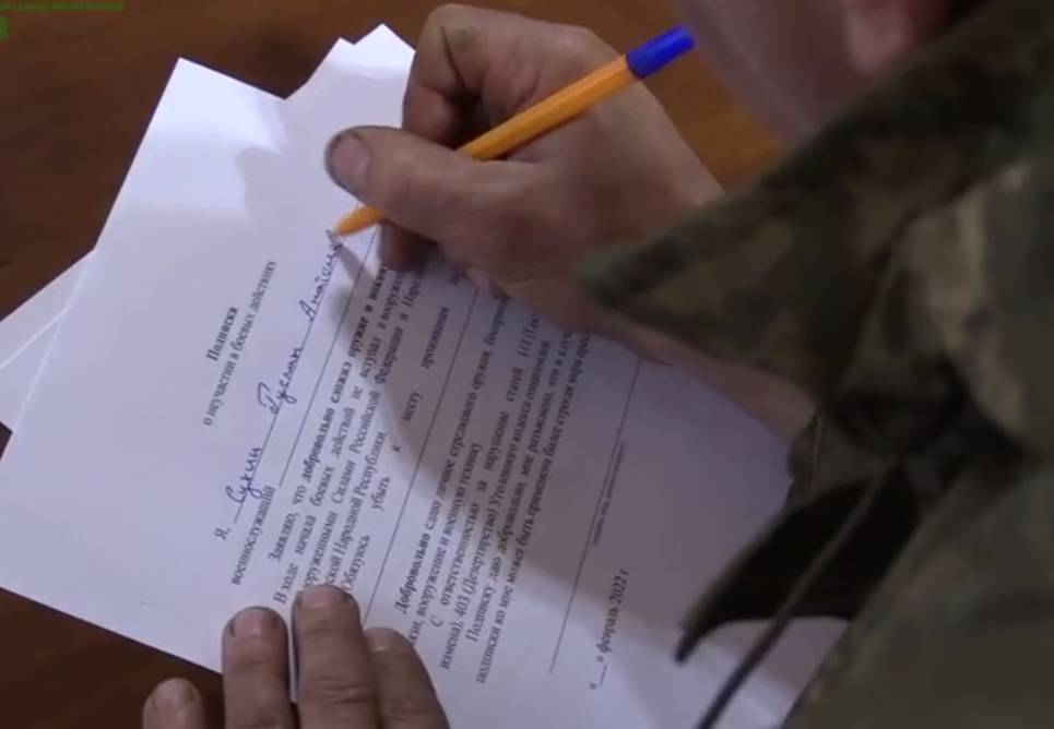 Украинский солдат подписывает подписку о неучастии в боевых действиях.