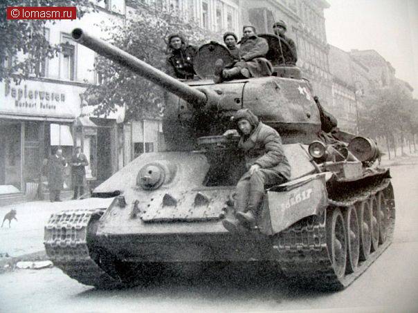 Танк Т-34 стоит напротив бумажно-канцелярского магазина на улице Берлина.