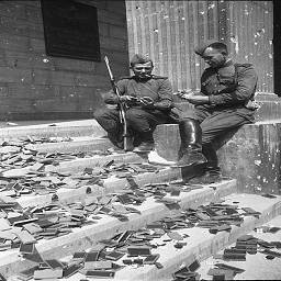 Советские солдаты у рейхсканцелярии рассматривают кучу немецких наград.
